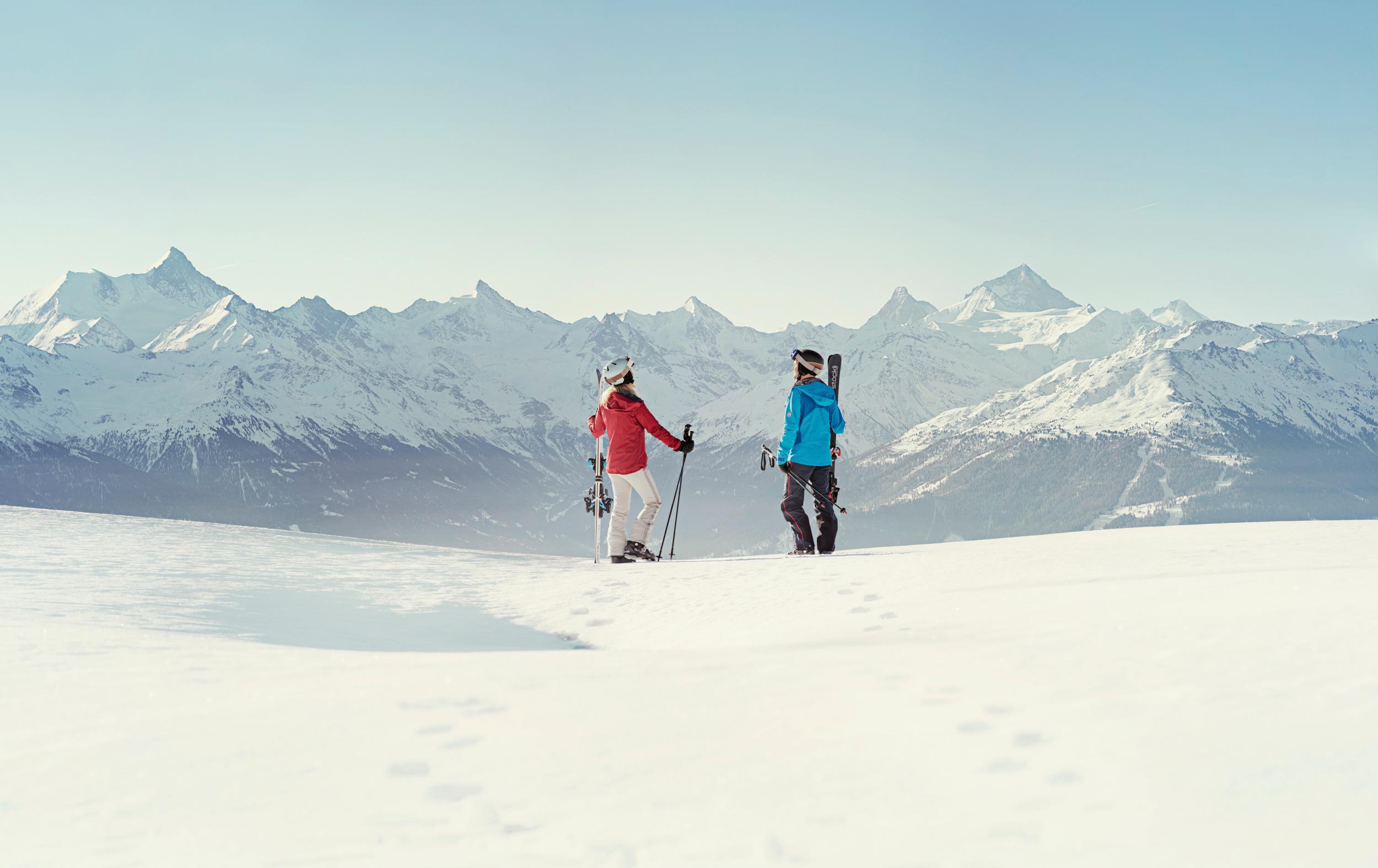 Couple taking break from skiing to admire view of Crans Montana ski resort